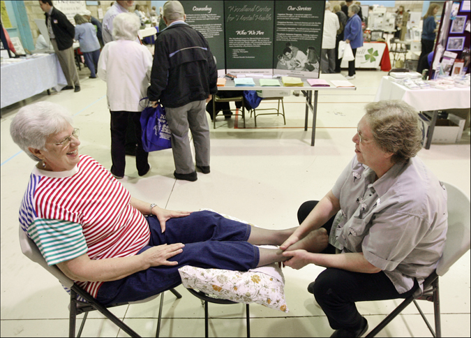 Sharon LaPesh, left, of Hannibal, Mo., is all smiles while receiving a foot massage from massage therapist Kimberly Kircher during the 2009 Senior Expo Thursday at the Admiral Coontz Armory in Hannibal. Numerous vendors manned booths at the event to promote their services for area senior citizens. For LaPesh, massage was a highlight of the expo. "Boy, that felt good," she said after Kircher completed her work. "That's like a little piece of heaven." H-W Photo/Philip Carlson